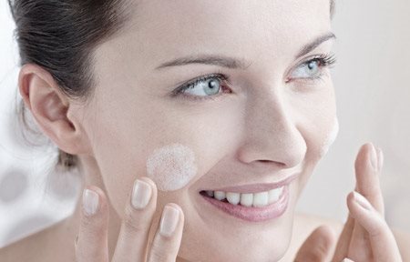 Woman applying care on her cheeks